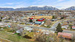 Aerial view of property and surrounding area with nearby suburban area and mountains