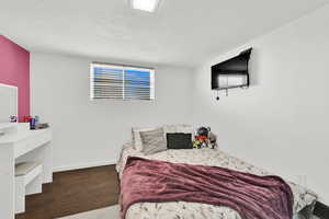 Bedroom with dark wood-type flooring and a textured ceiling