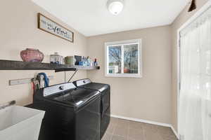 Laundry area featuring separate washer and dryer and light tile patterned flooring