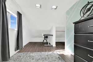 Interior space with dark wood-type flooring and lofted ceiling
