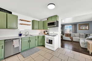 Kitchen with green cabinetry, stainless steel appliances, and light countertops