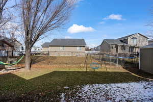 Fenced yard featuring a playground and a residential view