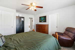 Carpeted bedroom featuring a ceiling fan