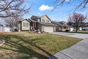 Traditional-style house featuring an attached garage, concrete driveway, stone siding, and stucco siding