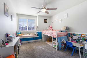 Carpeted bedroom featuring a ceiling fan and reading nook