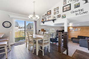 Dining room featuring lofted ceiling, a chandelier, and dark wood-type flooring