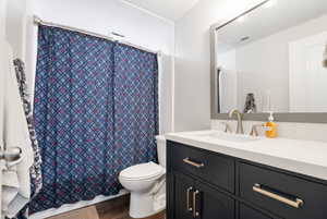 Full bathroom featuring vanity, a shower with shower curtain, and dark wood finished floors