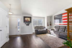 Living area featuring dark wood finished floors, lofted ceiling, and plenty of natural light