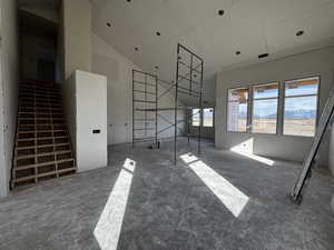 Unfurnished living room with a mountain view and vaulted ceiling