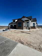 Modern farmhouse with a porch, board and batten siding, brick siding, and a mountain view