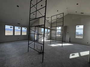 Unfurnished bedroom with a high ceiling and concrete floors