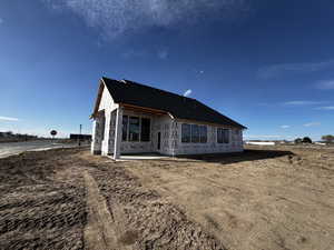View of front of house featuring a patio and roof with shingles
