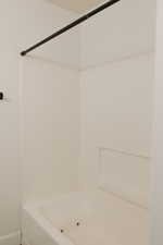 Bathroom with bathtub / shower combination and baseboards