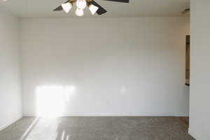 Unfurnished room featuring ceiling fan and carpet flooring