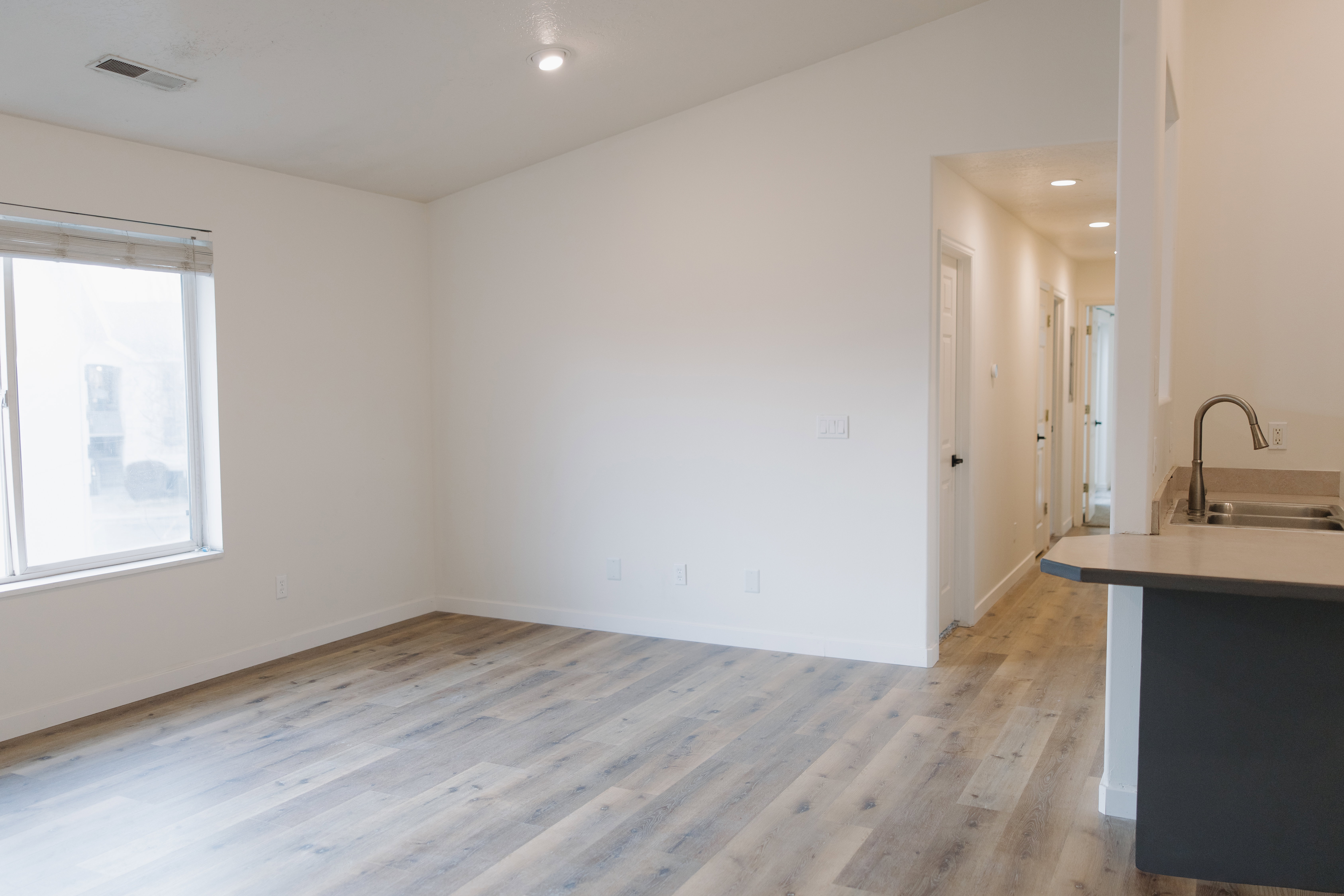 Kitchen featuring light wood finished floors, light countertops, recessed lighting, and a peninsula