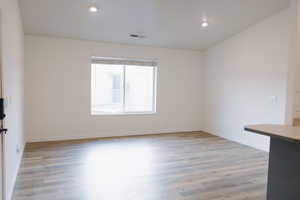 Empty room featuring light wood-type flooring and recessed lighting