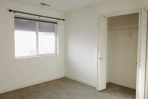 Unfurnished bedroom with carpet flooring and a closet