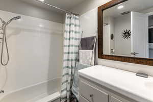Full bathroom featuring vanity and shower / bath combo with shower curtain