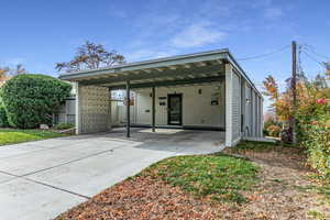 Back of house featuring driveway and a carport