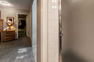 Corridor with a textured ceiling and baseboards