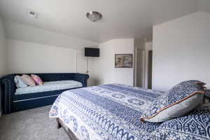 Bedroom featuring vaulted ceiling and carpet floors