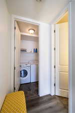 Laundry room with dark wood-type flooring, a textured ceiling, and independent washer and dryer