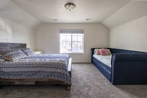 Carpeted bedroom featuring a textured ceiling and baseboards