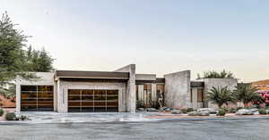 Contemporary home featuring concrete driveway and a garage