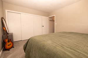 Carpeted bedroom featuring a closet