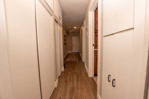 Corridor with wood finished floors and baseboards