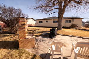 Back of property featuring a patio and a lawn