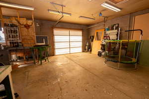 Garage with concrete block wall and a trampoline