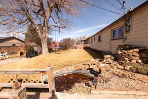Fenced backyard featuring a garden pond