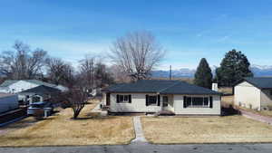 Ranch-style home with a front yard and a mountain view