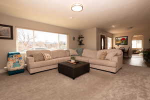 Living room featuring carpet and healthy amount of natural light