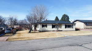 Ranch-style home with a chimney and a front lawn