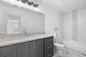 Full bathroom featuring vanity, tub / shower combination, and light marble finish floors