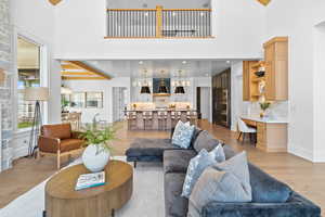 Living area featuring built in study area, light wood-type flooring, and a high ceiling