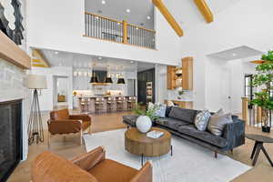 Living room with a fireplace, light wood-style flooring, beverage cooler, and recessed lighting
