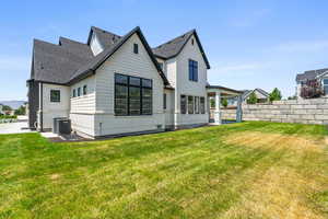 Rear view of house featuring a patio, a shingled roof, and brick siding