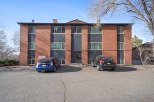 View of apartment building / complex with uncovered parking