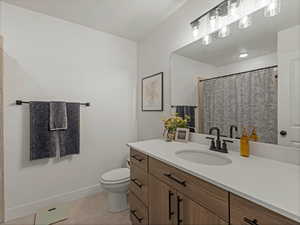 Bathroom featuring vanity, a shower with shower curtain, and light tile patterned flooring