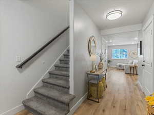 Stairway with wood finished floors and recessed lighting