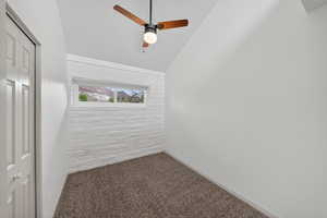 Unfurnished room with dark colored carpet and ceiling fan