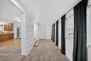 Corridor featuring light colored carpet and a textured ceiling