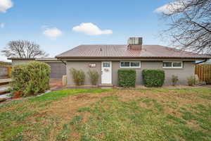 View of front of home featuring stucco siding and a metal roof
