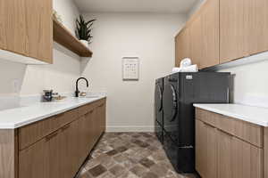 Laundry area featuring cabinet space, stone finish floors, and separate washer and dryer