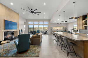 Living room featuring a large fireplace, a ceiling fan, recessed lighting, healthy amount of natural light, and light tile patterned flooring