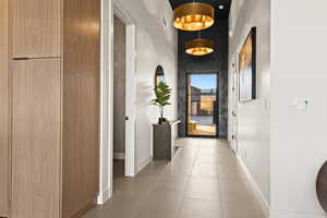 Hall featuring tile patterned floors and a high ceiling