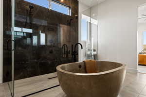 Ensuite bathroom with tile patterned floors, a freestanding bath, and a marble finish shower